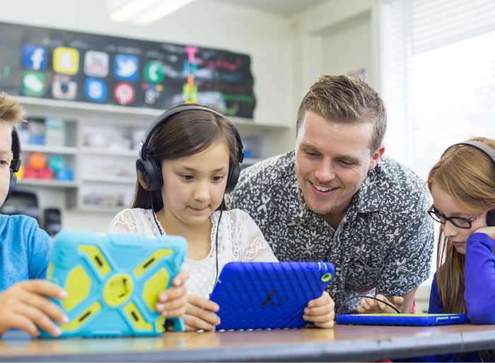 Children answering spelling questions on tablets