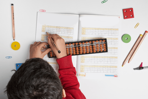 Child completing a maths workbook