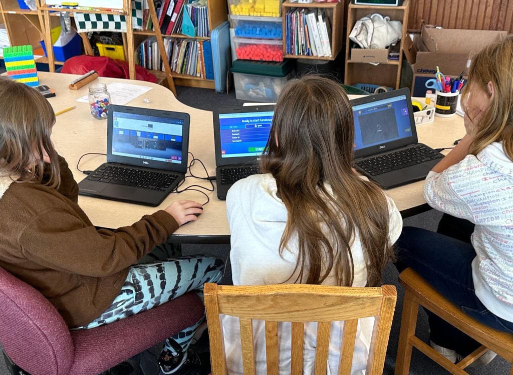 Three students play Sumdog in class